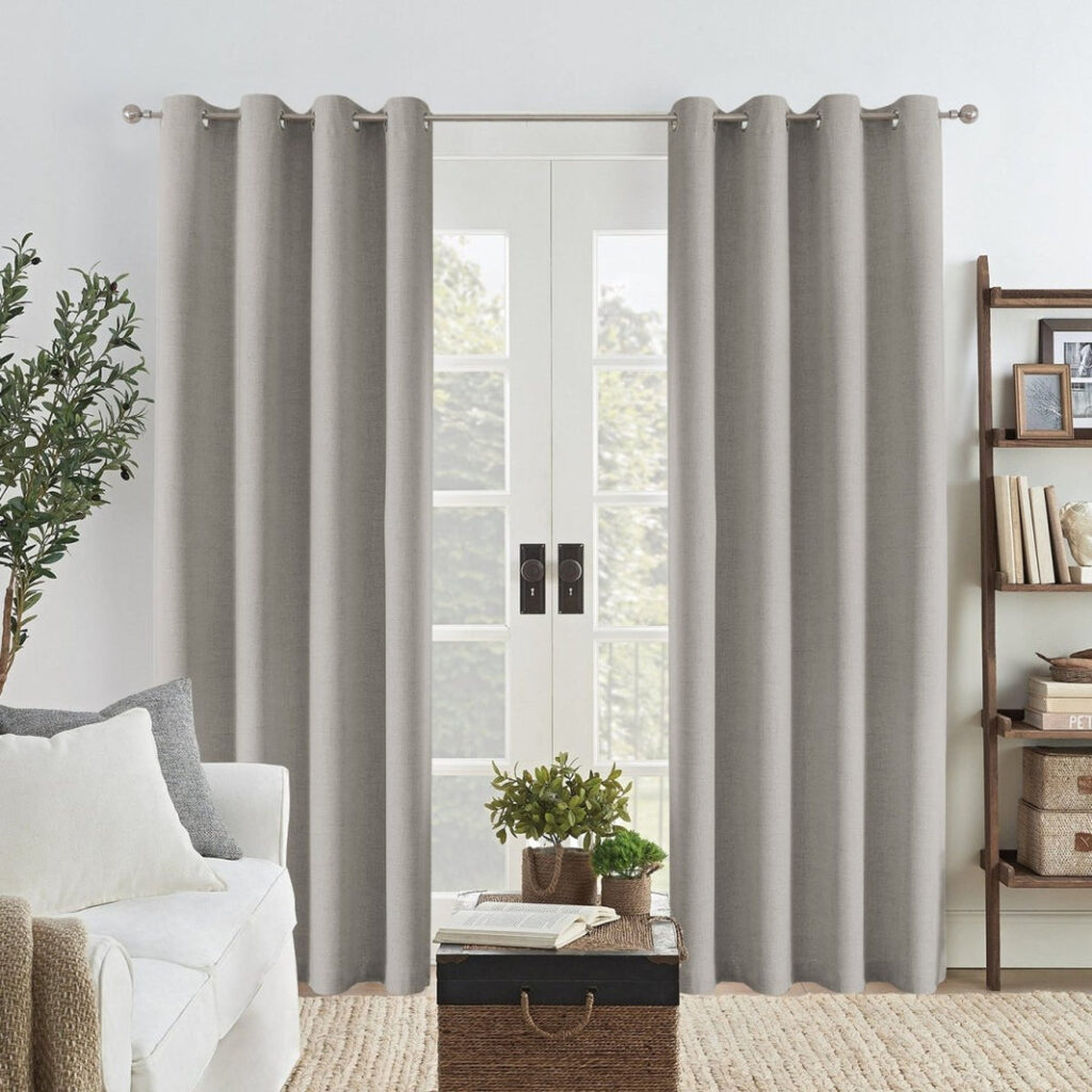 Joydeco grey linen blackout curtains with grommets framing a glass door in a modern living room